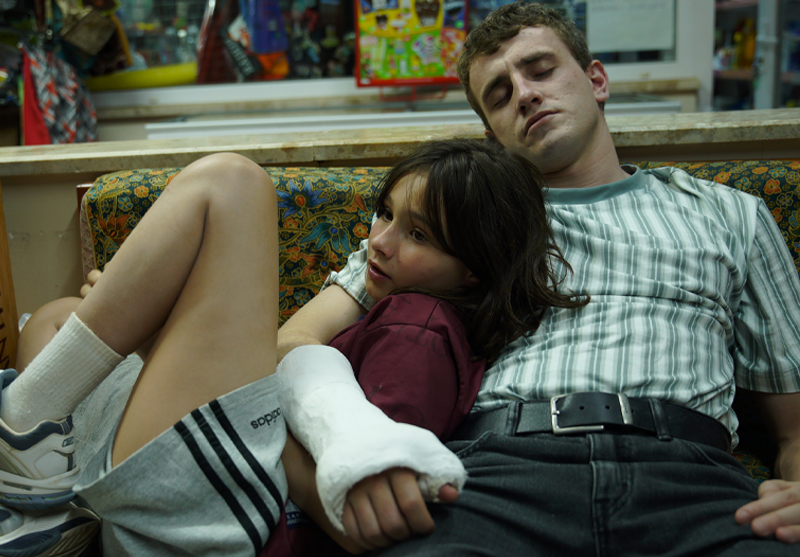 A man and a girl sleep on a sofa.