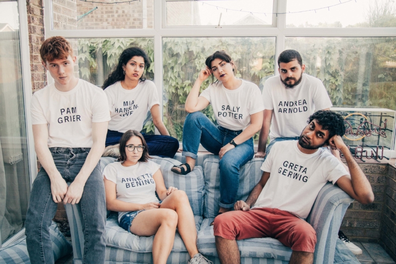 Girls on Tops, a group of young people sit round on a sofa in a conservatory wearing white tshirts with the names of female filmmakers on them in black capital letters